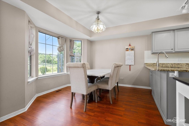 61 King Dr, Streamwood, IL 60107 - dining area featuring a chandelier, dark wood finished floors, and a raised ceiling