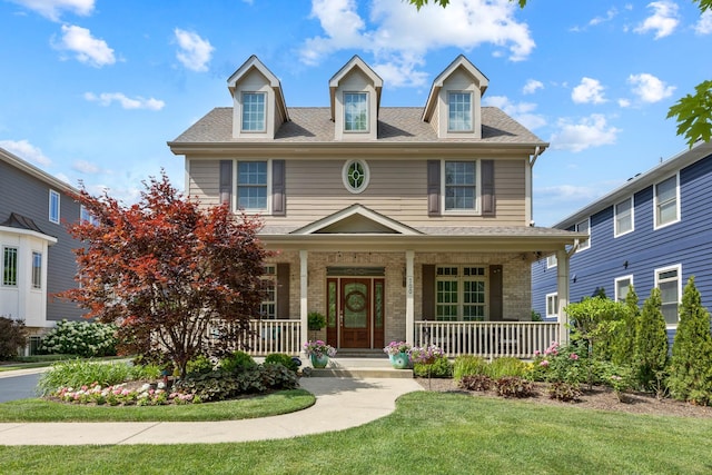 700 E Sunnyside Ave, Libertyville, IL 60048 - view of front facade with a porch, a front lawn, and brick siding
