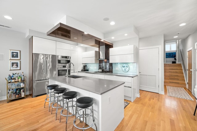 1008 N Larrabee St Unit 2S, Chicago, IL 60610 - kitchen with modern cabinets, stainless steel appliances, wall chimney exhaust hood, a breakfast bar, and recessed lighting