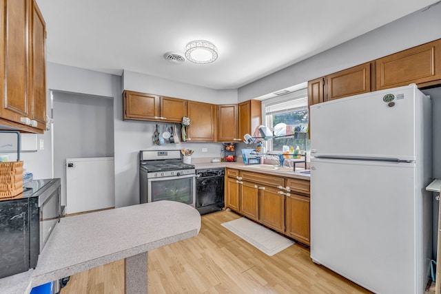 9113 Sycamore Dr, Hickory Hills, IL 60457 - kitchen featuring freestanding refrigerator, gas stove, black dishwasher, light wood-style floors, and light countertops