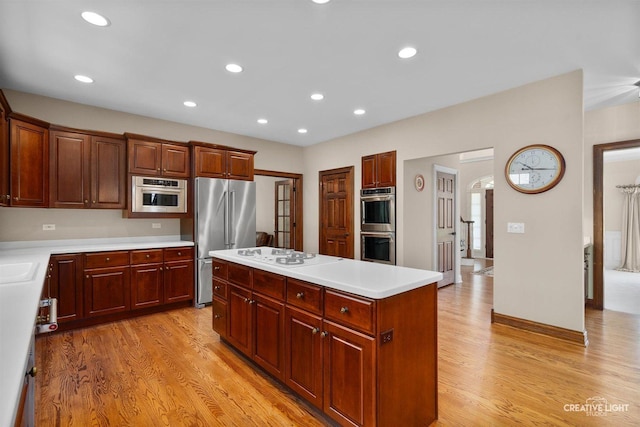 1105 Thoroughbred Cir, Saint Charles, IL 60174 - kitchen with appliances with stainless steel finishes, light wood finished floors, arched walkways, a center island, and light countertops
