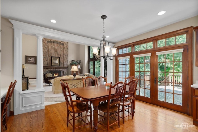 1105 Thoroughbred Cir, Saint Charles, IL 60174 - dining area with light wood finished floors, a brick fireplace, a chandelier, french doors, and recessed lighting