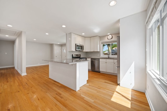 6037 N Nagle Ave, Chicago, IL 60646 - kitchen featuring stainless steel appliances, white cabinets, light wood finished floors, recessed lighting, and light stone countertops