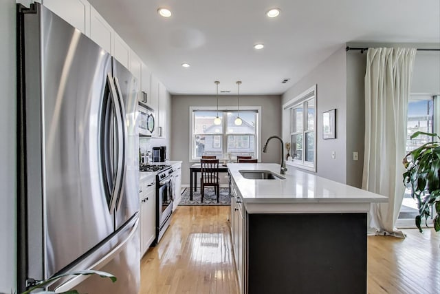 1601 N Paulina St Unit 2D, Chicago, IL 60622 - kitchen featuring stainless steel appliances, light countertops, recessed lighting, decorative light fixtures, and light wood-style flooring