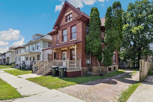 809 W 4th St, Sterling, IL 61081 - townhome / multi-family property with covered porch, brick siding, a residential view, and a front yard
