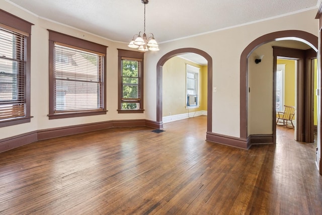 809 W 4th St, Sterling, IL 61081 - spare room featuring arched walkways, wood-type flooring, ornamental molding, and a chandelier