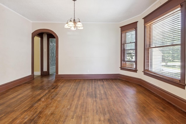809 W 4th St, Sterling, IL 61081 - unfurnished room with wood finished floors, a chandelier, crown molding, and arched walkways