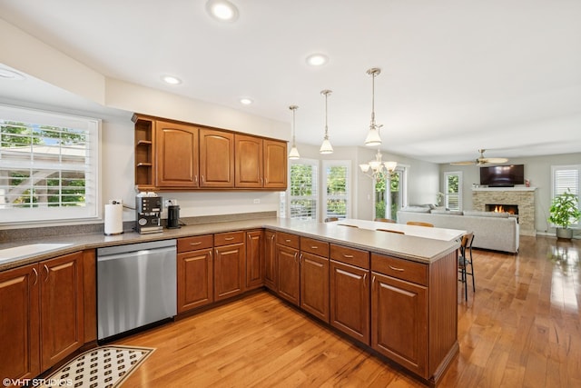 1460 Canter Ln, Bartlett, IL 60103 - kitchen with dishwasher, light wood finished floors, a peninsula, a warm lit fireplace, and brown cabinets