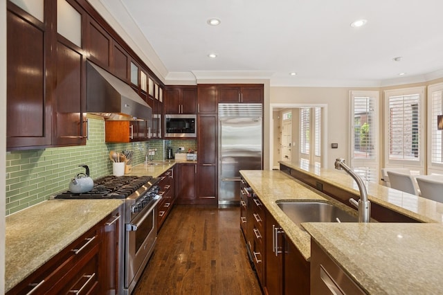 2446 N Janssen Ave, Chicago, IL 60614 - kitchen featuring high end appliances, range hood, light stone counters, crown molding, and tasteful backsplash