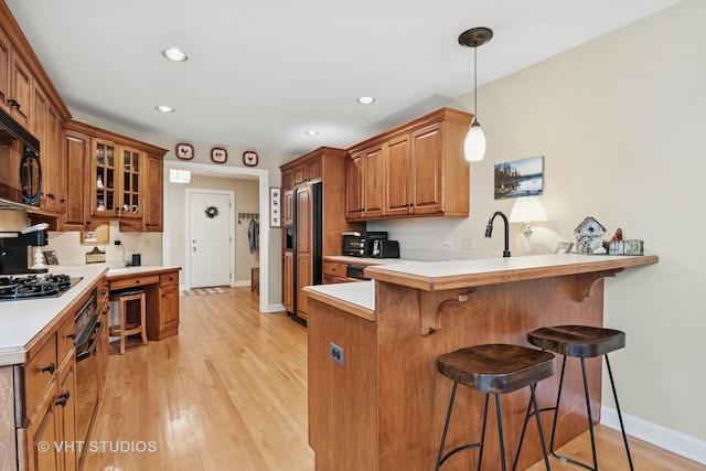 3716 King Charles Ln, Saint Charles, IL 60174 - kitchen featuring brown cabinetry, a breakfast bar area, gas stovetop, a peninsula, and paneled built in refrigerator