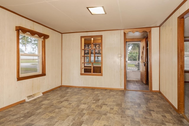607 W Grant Ave, Pontiac, IL 61764 - spare room with plenty of natural light, crown molding, stone finish floors, and wooden walls