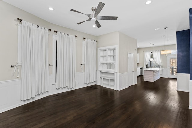 4738 S Champlain Ave, Chicago, IL 60615 - unfurnished living room featuring wainscoting, dark wood-type flooring, ceiling fan, recessed lighting, and a decorative wall
