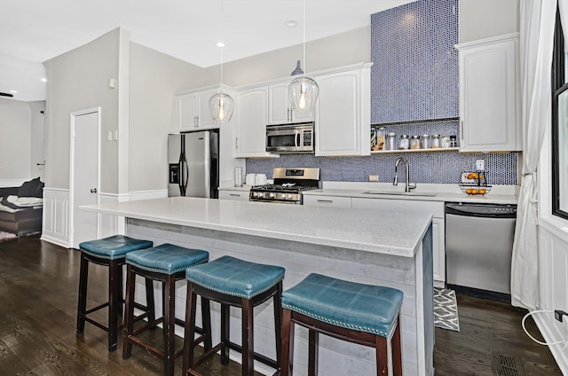 4738 S Champlain Ave, Chicago, IL 60615 - kitchen featuring stainless steel appliances, dark wood-style floors, decorative backsplash, white cabinetry, and a wainscoted wall