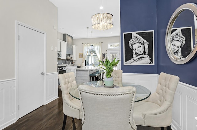 4738 S Champlain Ave, Chicago, IL 60615 - dining space featuring a chandelier, dark wood-type flooring, a wainscoted wall, and a decorative wall