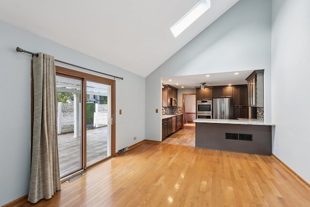 584 Beaconsfield Ave, Naperville, IL 60565 - kitchen featuring stainless steel appliances, decorative backsplash, high vaulted ceiling, a skylight, and light wood finished floors