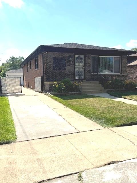 14240 S Manistee Ave, Burnham, IL 60633 - view of front of home with brick siding, a front lawn, a gate, and a garage