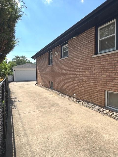 14240 S Manistee Ave, Burnham, IL 60633 - view of side of home with brick siding, an outdoor structure, and a garage