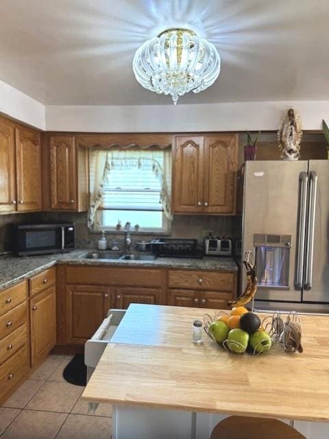 14240 S Manistee Ave, Burnham, IL 60633 - kitchen with stainless steel appliances, brown cabinets, a chandelier, and wood counters