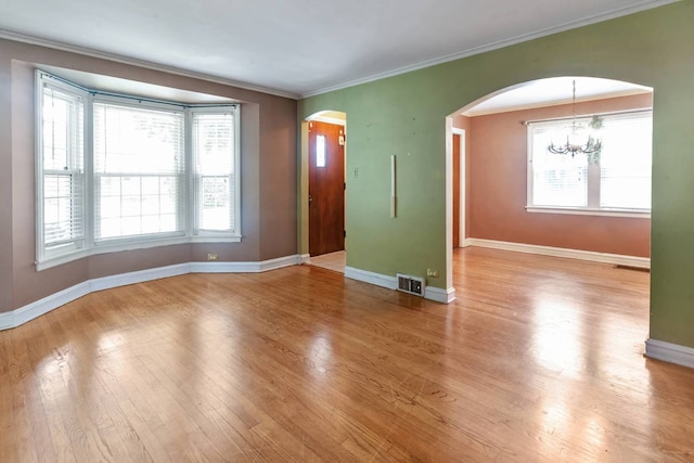 1710 N 74th Ct, Elmwood Park, IL 60707 - unfurnished room featuring arched walkways, plenty of natural light, a chandelier, and ornamental molding