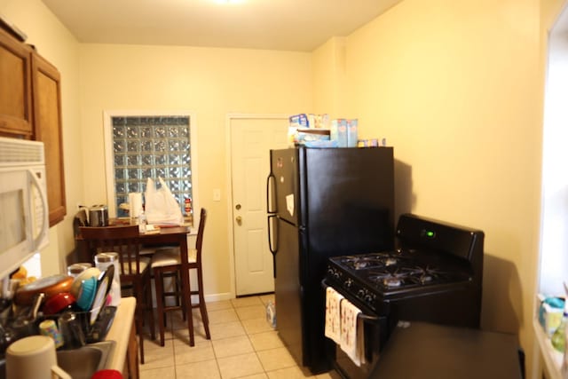 6948 S Eberhart Ave, Chicago, IL 60637 - kitchen with black appliances, brown cabinetry, and light tile patterned floors