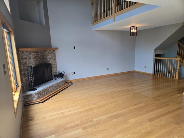 8452 Dunmore Dr, Tinley Park, IL 60487 - unfurnished living room with a fireplace, wood finished floors, and a towering ceiling