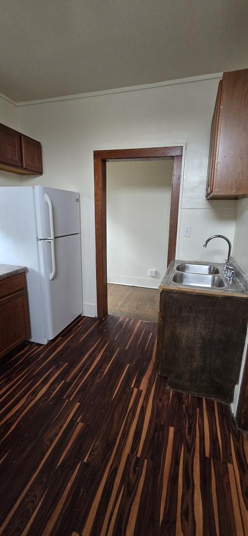83 W 15th St, Chicago Heights, IL 60411 - kitchen with freestanding refrigerator, dark wood-style floors, crown molding, and dark brown cabinets
