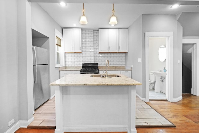 6409 S Champlain Ave, Chicago, IL 60637 - kitchen featuring freestanding refrigerator, light wood-type flooring, black range with gas cooktop, white cabinets, and tasteful backsplash