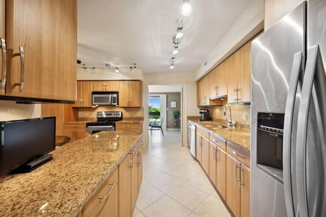 1671 Mission Hills Rd Unit 501, Northbrook, IL 60062 - kitchen featuring stainless steel appliances, track lighting, light tile patterned floors, backsplash, and light stone countertops