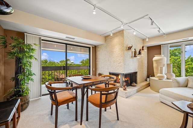 1671 Mission Hills Rd Unit 501, Northbrook, IL 60062 - dining room featuring rail lighting, light carpet, and a large fireplace