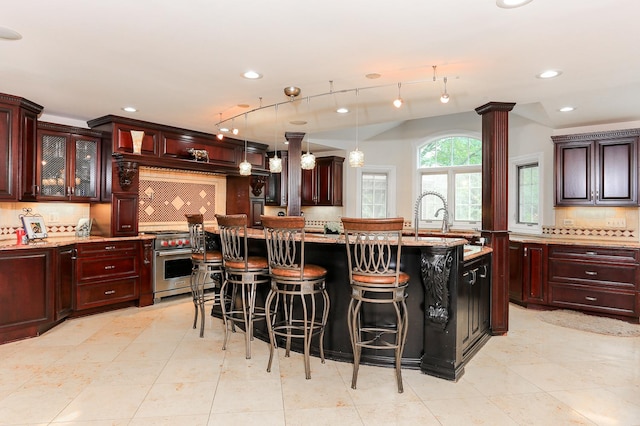 560 81st St, Burr Ridge, IL 60527 - kitchen with high end stainless steel range, decorative backsplash, a breakfast bar, pendant lighting, and dark brown cabinets