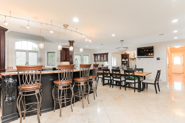 560 81st St, Burr Ridge, IL 60527 - kitchen featuring recessed lighting, a kitchen breakfast bar, dark brown cabinets, decorative light fixtures, and light countertops