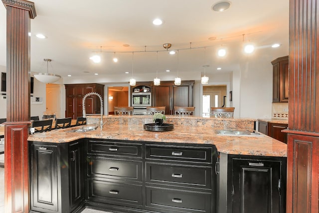 560 81st St, Burr Ridge, IL 60527 - kitchen with dark cabinetry, decorative columns, a large island, backsplash, and recessed lighting
