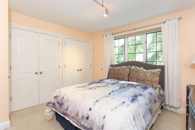 560 81st St, Burr Ridge, IL 60527 - bedroom with multiple closets, light carpet, and track lighting