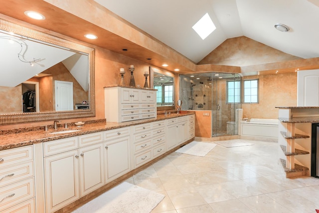 560 81st St, Burr Ridge, IL 60527 - bathroom with vaulted ceiling, a bath, a shower stall, double vanity, and a skylight