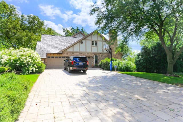 560 81st St, Burr Ridge, IL 60527 - tudor home with decorative driveway, a chimney, stucco siding, an attached garage, and stone siding