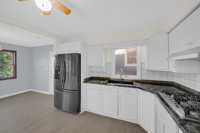 26W278 Harrison Ave, Winfield, IL 60190 - kitchen with appliances with stainless steel finishes, under cabinet range hood, dark countertops, light wood-style flooring, and white cabinetry