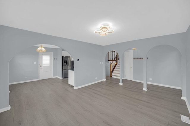 26W278 Harrison Ave, Winfield, IL 60190 - unfurnished living room with arched walkways, wood finished floors, and stairway