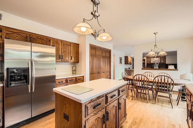 3825 Charlemagne Dr, Hoffman Estates, IL 60192 - kitchen with stainless steel fridge, light wood-style flooring, light countertops, pendant lighting, and brown cabinets