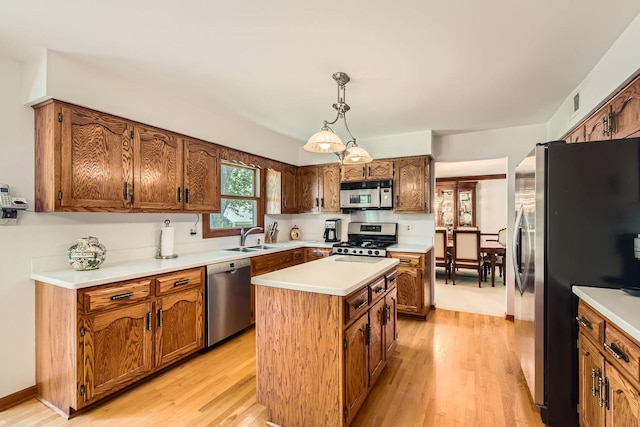 3825 Charlemagne Dr, Hoffman Estates, IL 60192 - kitchen featuring stainless steel appliances, a center island, light wood finished floors, brown cabinets, and light countertops