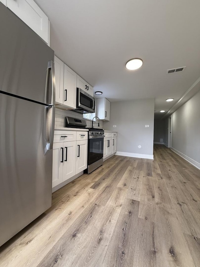 1400 W 73rd Pl, Chicago, IL 60636 - kitchen with appliances with stainless steel finishes, light wood finished floors, and white cabinets