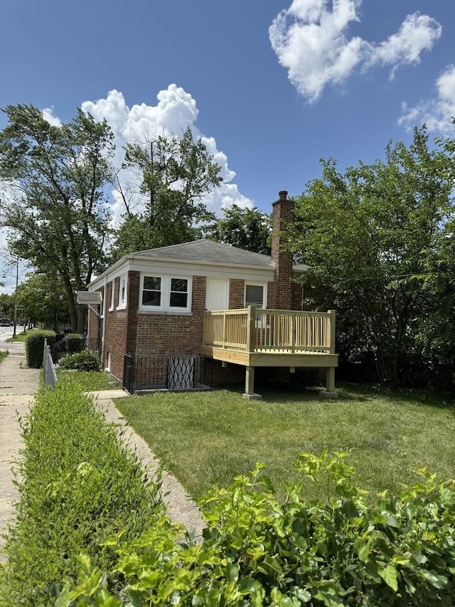 1400 W 73rd Pl, Chicago, IL 60636 - back of property with brick siding, a wooden deck, a chimney, and a yard