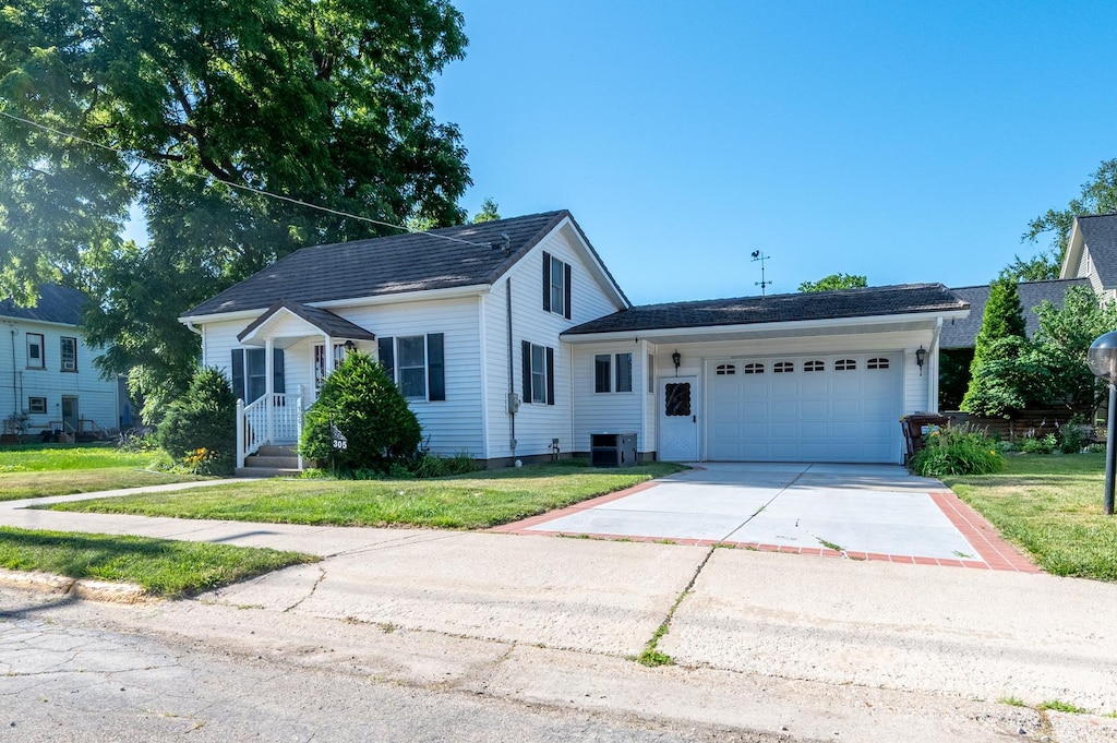 305 Monroe St, Oregon, IL 61061 - view of front of house featuring a garage, a front yard, and concrete driveway