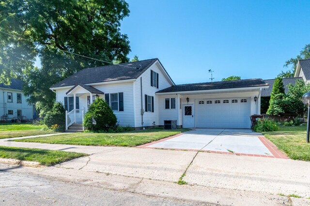 305 Monroe St, Oregon, IL 61061 - view of front of house featuring a garage, a front yard, and concrete driveway
