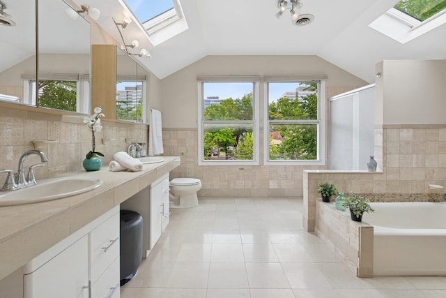 1006 Foster St, Evanston, IL 60201 - full bathroom with a skylight, tile walls, a bath, double vanity, and vaulted ceiling
