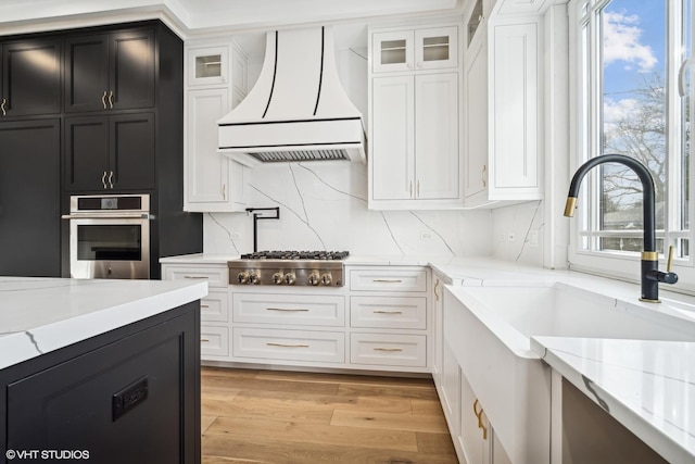 124 Lincoln St, Glenview, IL 60025 - kitchen featuring appliances with stainless steel finishes, premium range hood, white cabinets, and glass insert cabinets