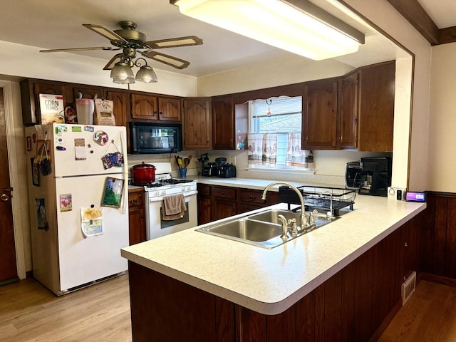 261 S Edison Ave, Elgin, IL 60123 - kitchen featuring white appliances, light countertops, light wood-style floors, a peninsula, and a ceiling fan
