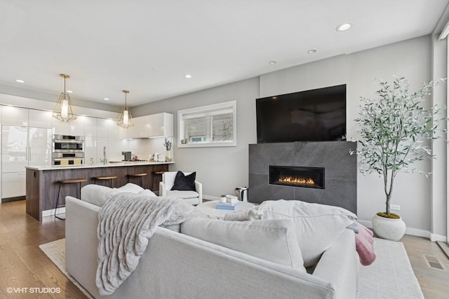 2237 N Hoyne Ave Unit 3S, Chicago, IL 60647 - living area with a glass covered fireplace, light wood-style flooring, and recessed lighting