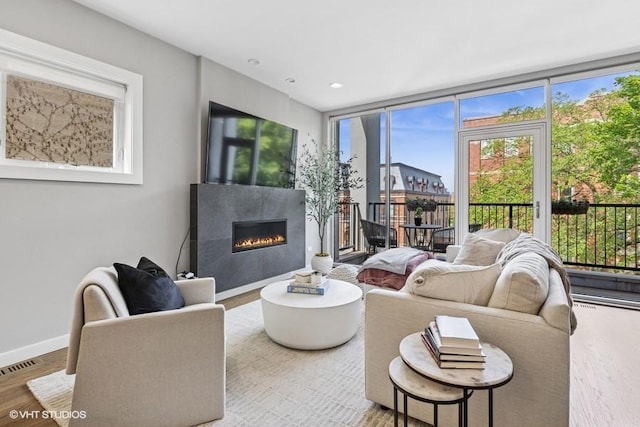 2237 N Hoyne Ave Unit 3S, Chicago, IL 60647 - living room featuring a glass covered fireplace, wood finished floors, and recessed lighting