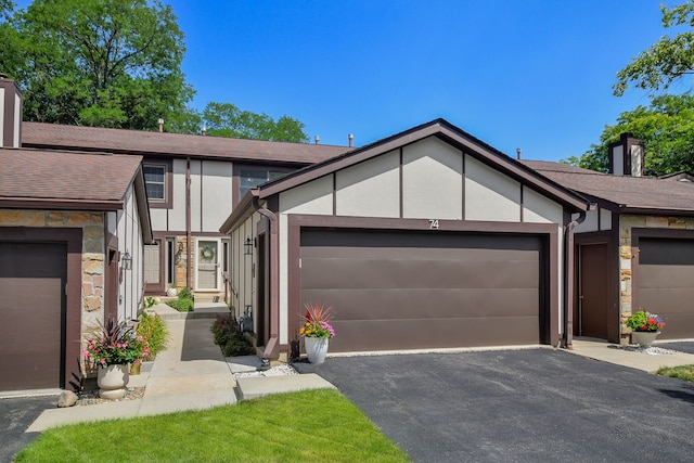 74 White Oak Cir, Saint Charles, IL 60174 - tudor-style house featuring an attached garage, driveway, a chimney, and stone siding