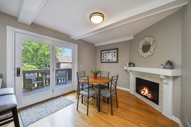 74 White Oak Cir, Saint Charles, IL 60174 - dining space featuring beam ceiling, light wood-style flooring, and a tiled fireplace